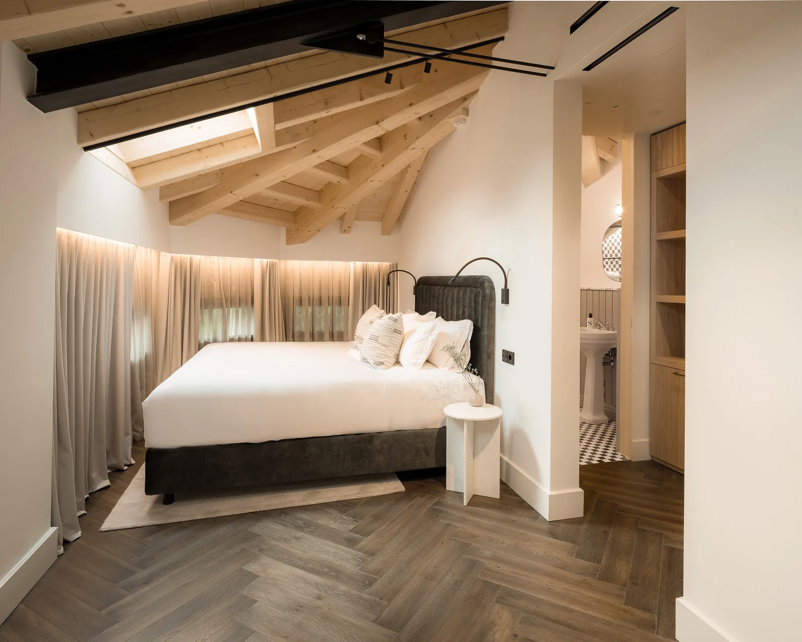 Camera con soffitto in legno e bagno adiacente